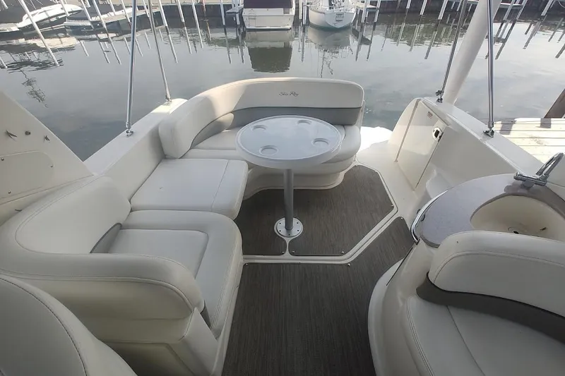 Slide: The Image of 2006 Sea Ray Sundancer 260 interior with seating and table, docked at marina. - 17