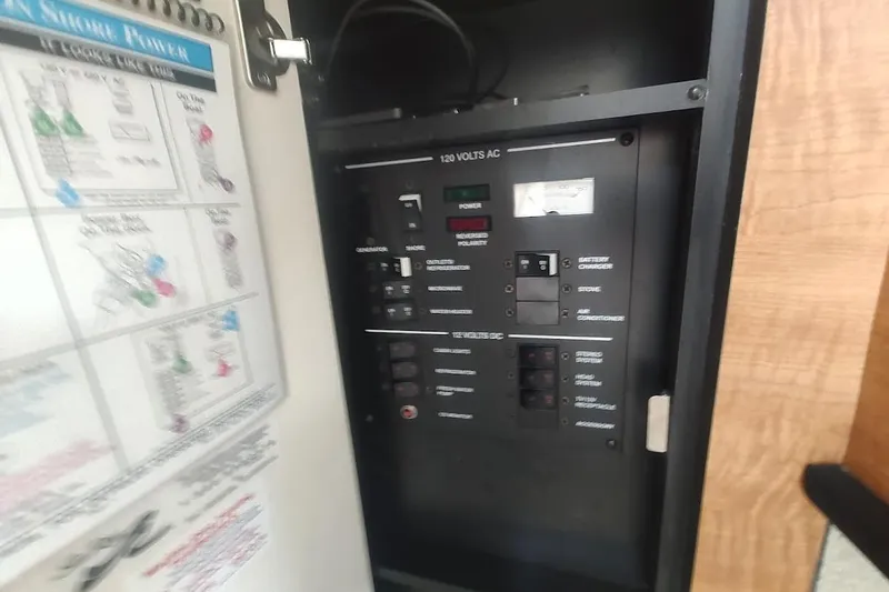 Slide: The Image of Electrical panel inside a 2006 Sea Ray Sundancer 260 boat, showing power controls. - 19