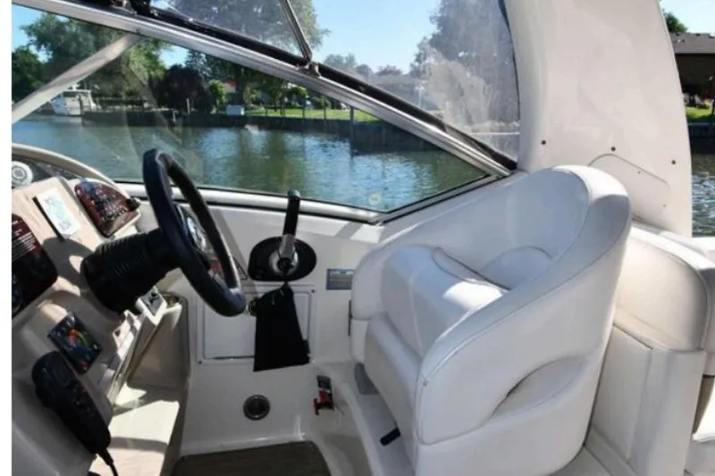 Slide: The Image of 2006 Sea Ray Sundancer 260 helm with white captain's chair and steering wheel. - 3