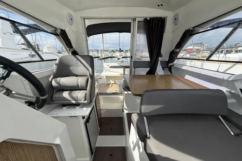 Slide: The Image of Interior of 2021 Beneteau Antares 8 boat, featuring helm and seating area. - 11