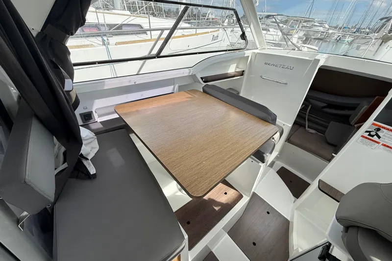 Slide: The Image of Interior of 2021 Beneteau Antares 8, featuring a wooden table and seating area. - 13