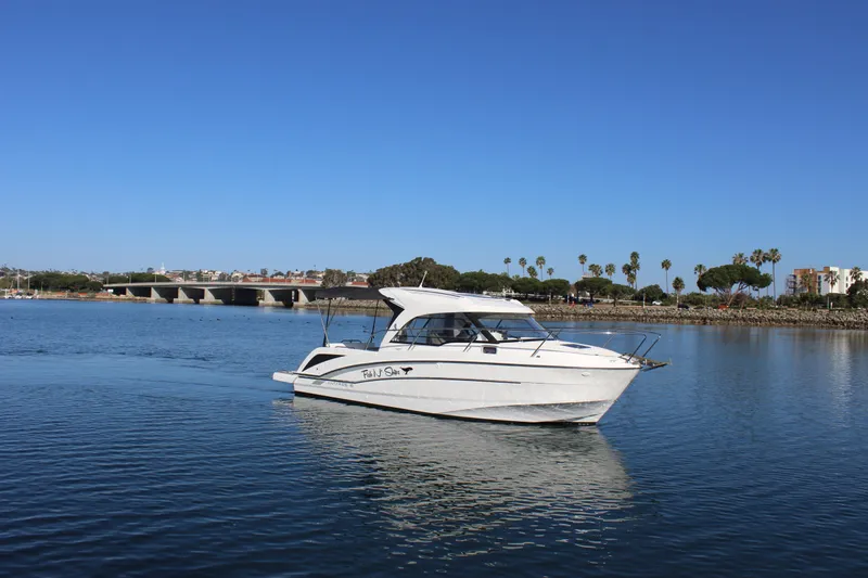 Slide: The Image of 2021 Beneteau Antares 8 boat cruising on a calm, scenic waterway. - 2
