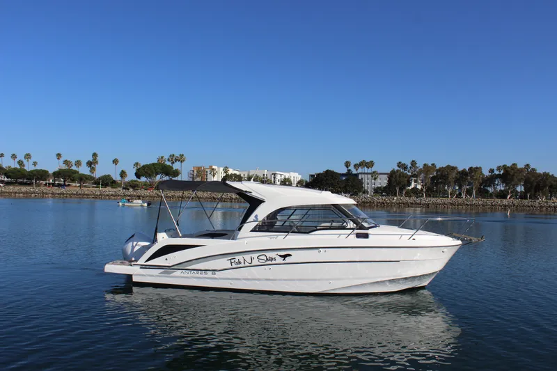 Slide: The Image of 2021 Beneteau Antares 8 boat on calm water, clear sky, palm trees in background. - 7