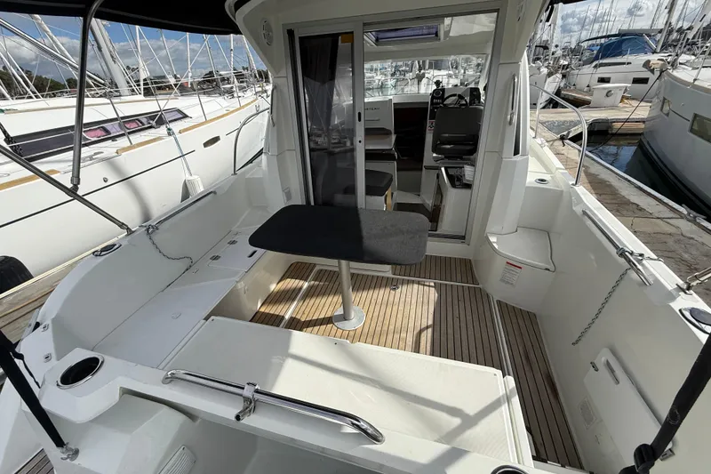 Slide: The Image of 2021 Beneteau Antares 8 boat interior with seating and table, docked at marina. - 8