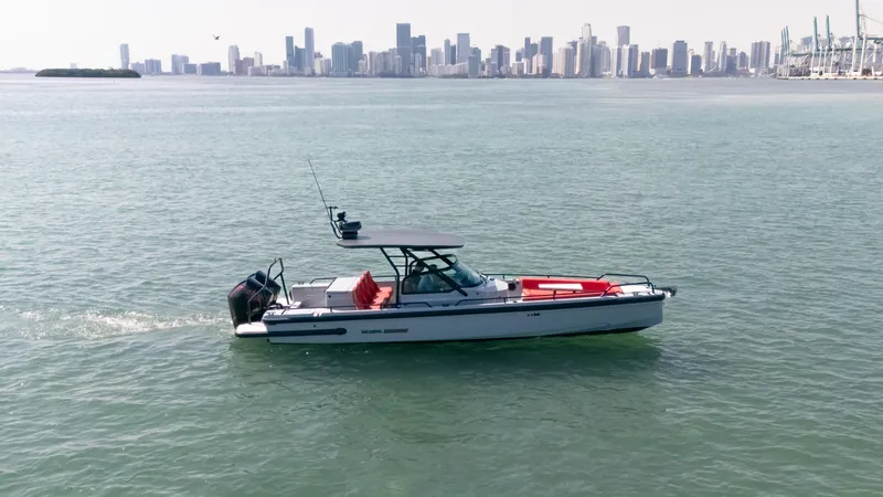 Slide: The Image of 2023 BRABUS Shadow 500 T-Top boat cruising near city skyline. - 11
