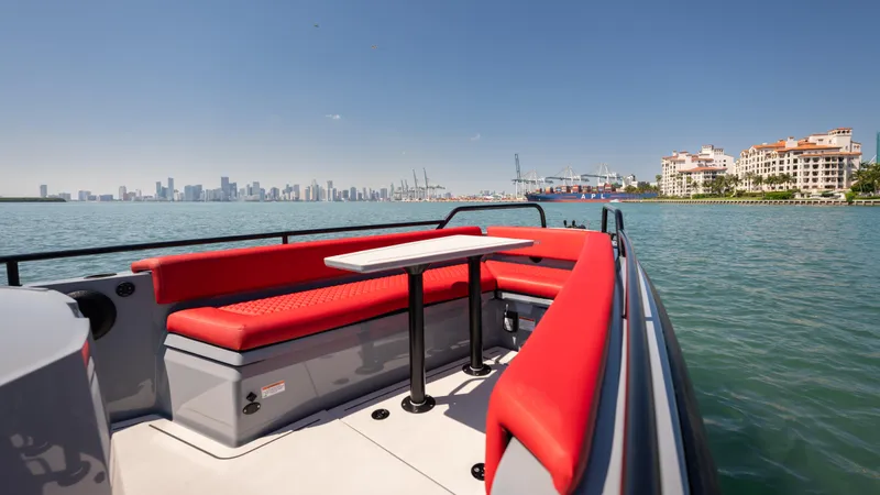 Slide: The Image of 2023 BRABUS Shadow 500 T-Top boat with red seating, city skyline in background. - 18