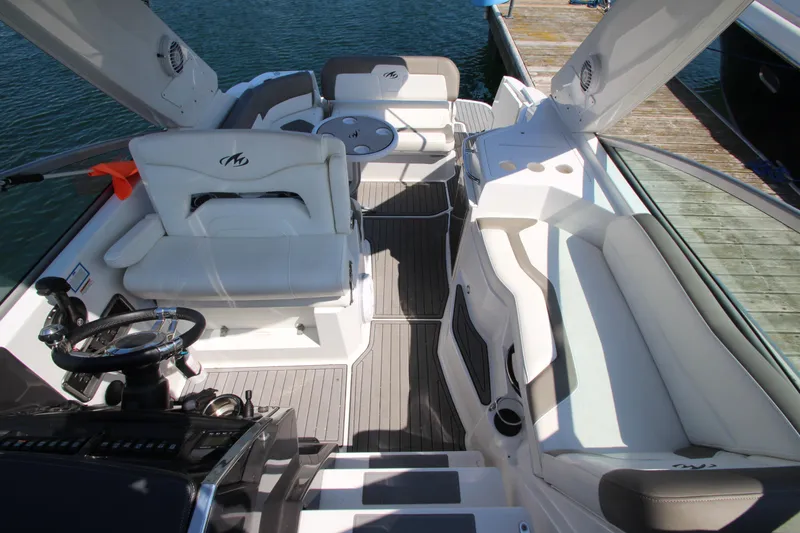 Slide: The Image of 2018 Monterey 295 Sport Yacht interior with white seating and sleek design at dock. - 19