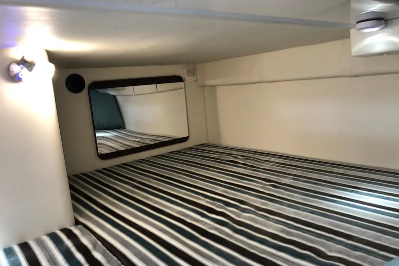 Slide: The Image of Interior cabin of 2018 Monterey 295 Sport Yacht with striped bedding and mirror. - 23