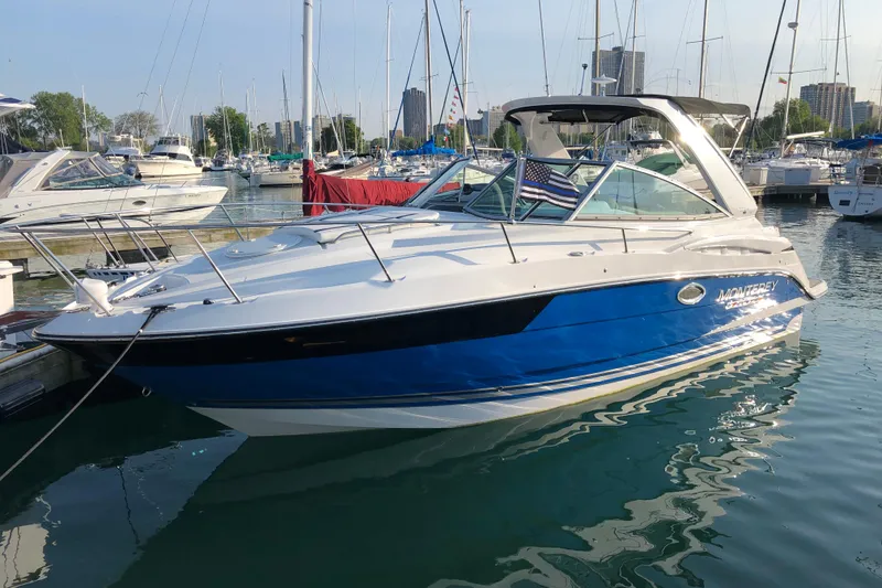 Slide: The Image of 2018 Monterey 295 Sport Yacht docked in a marina, surrounded by other boats. - 3