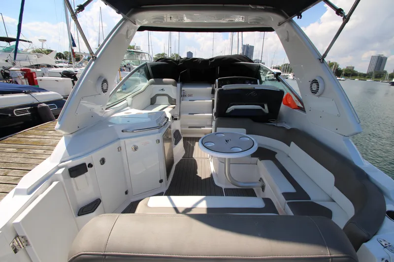 Slide: The Image of 2018 Monterey 295 Sport Yacht interior with seating and table, docked at marina. - 7
