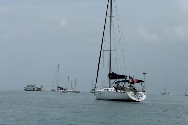 Slide: The Image of Sailboat Jeanneau Sun Odyssey 37, 2003 model, anchored in calm waters with other boats nearby. - 10