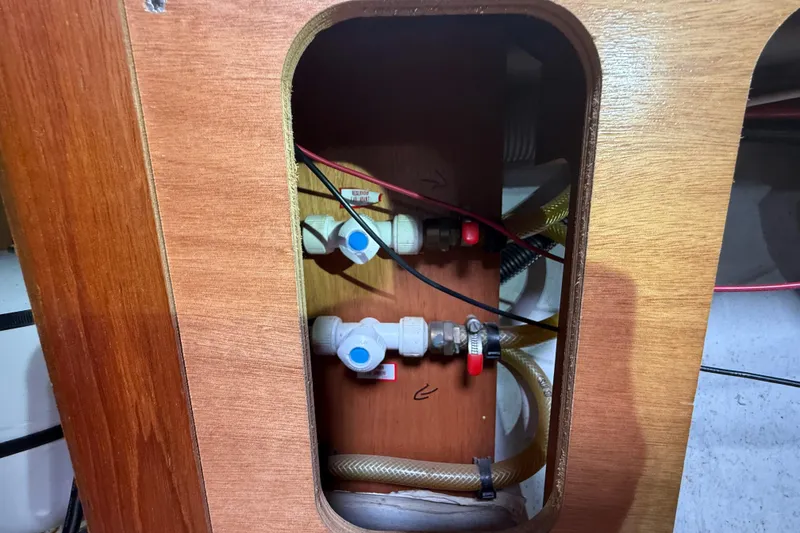 Slide: The Image of Plumbing system inside a 2003 Jeanneau Sun Odyssey 37 sailboat, featuring valves and hoses. - 104
