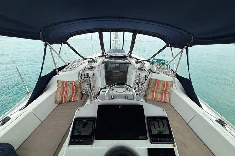 Slide: The Image of Cockpit of 2003 Jeanneau Sun Odyssey 37 sailboat with navigation instruments and striped cushions. - 12