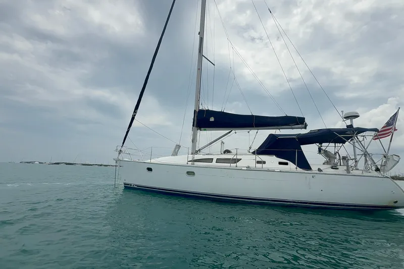 Slide: The Image of Sailing yacht Jeanneau Sun Odyssey 37, 2003 model, on calm waters under cloudy skies. - 2