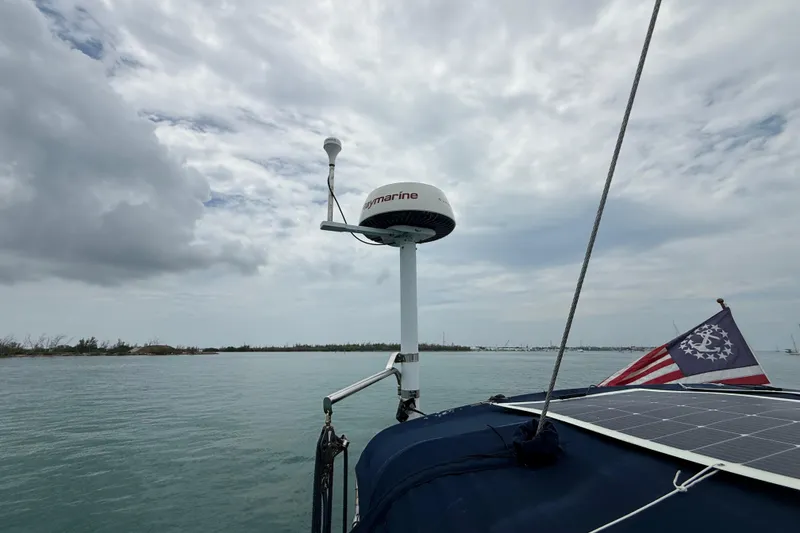 Slide: The Image of 2003 Jeanneau Sun Odyssey 37 sailboat with radar and solar panel, under cloudy sky. - 23