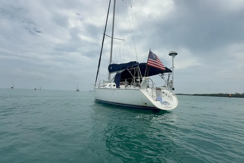 Slide: The Image of Sailboat Jeanneau Sun Odyssey 37, 2003 model, anchored in calm waters under cloudy skies. - 5
