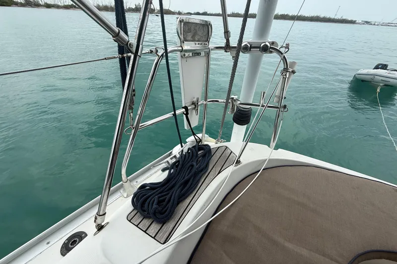 Slide: The Image of 2003 Jeanneau Sun Odyssey 37 sailboat deck with ropes and railing, anchored in calm waters. - 51