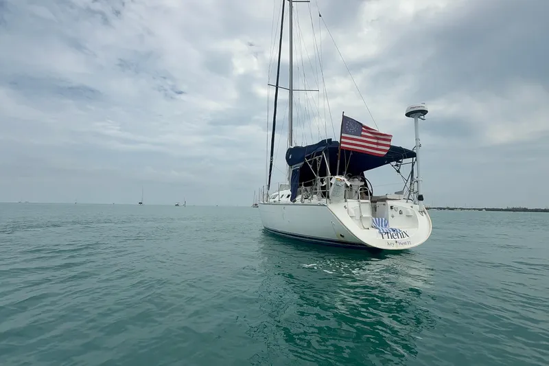 Slide: The Image of 2003 Jeanneau Sun Odyssey 37 sailboat on calm ocean waters under cloudy skies. - 6