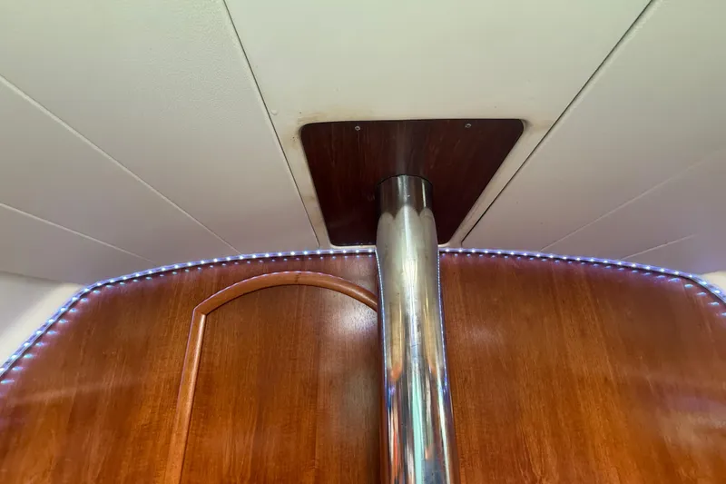 Slide: The Image of Interior of 2003 Jeanneau Sun Odyssey 37 sailboat with wooden paneling and metal support pole. - 67