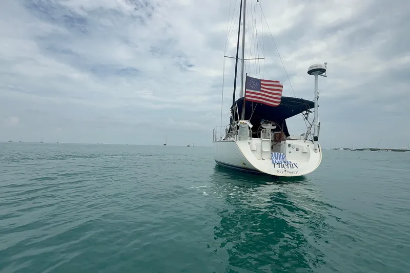Slide: The Image of 2003 Jeanneau Sun Odyssey 37 sailboat on calm waters, displaying an American flag. - 7