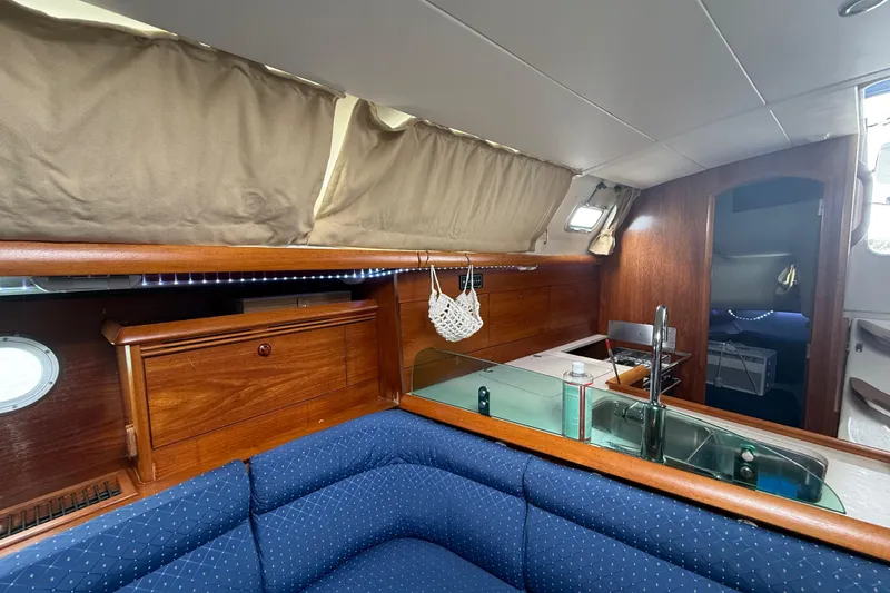Slide: The Image of Interior of 2003 Jeanneau Sun Odyssey 37 sailboat with wooden cabinetry and blue seating. - 71