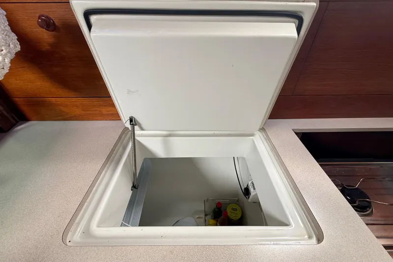 Slide: The Image of Open fridge compartment on 2003 Jeanneau Sun Odyssey 37 yacht, showing interior storage space. - 75