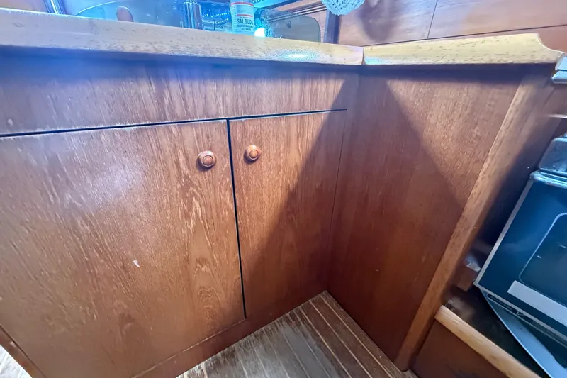 Slide: The Image of Wooden cabinetry in the galley of a 2003 Jeanneau Sun Odyssey 37 sailboat. - 78