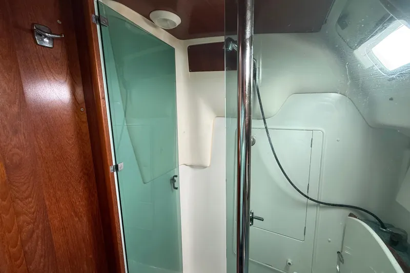 Slide: The Image of Shower area inside 2003 Jeanneau Sun Odyssey 37 sailboat, featuring glass door and wooden accents. - 89