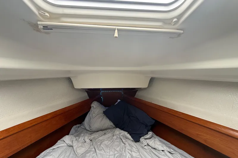 Slide: The Image of Cozy cabin interior of 2003 Jeanneau Sun Odyssey 37 sailboat with bedding and wooden trim. - 91