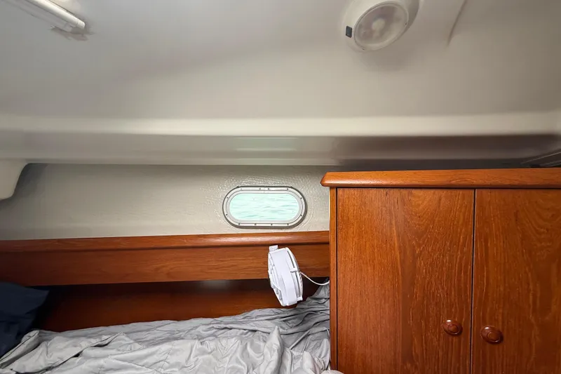 Slide: The Image of Interior cabin of 2003 Jeanneau Sun Odyssey 37 with wooden cabinetry and bedding. - 92