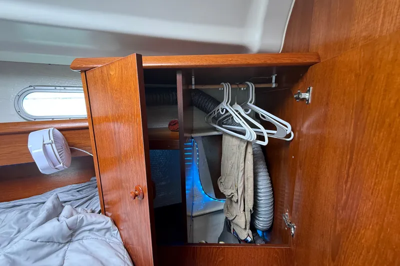 Slide: The Image of Wooden closet interior on 2003 Jeanneau Sun Odyssey 37 sailboat with hangers and ventilation. - 94