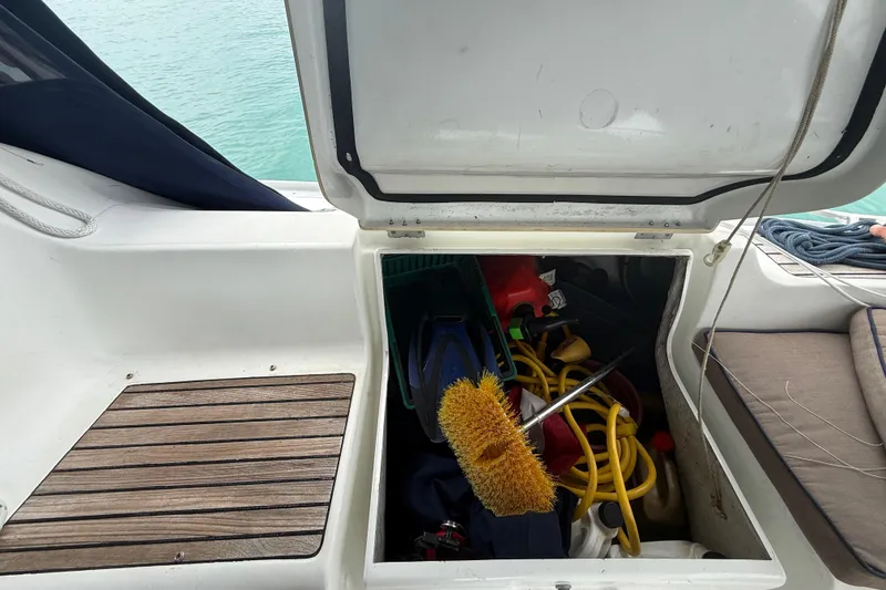 Slide: The Image of Open storage compartment on 2003 Jeanneau Sun Odyssey 37 sailboat, containing cleaning supplies and equipment. - 98
