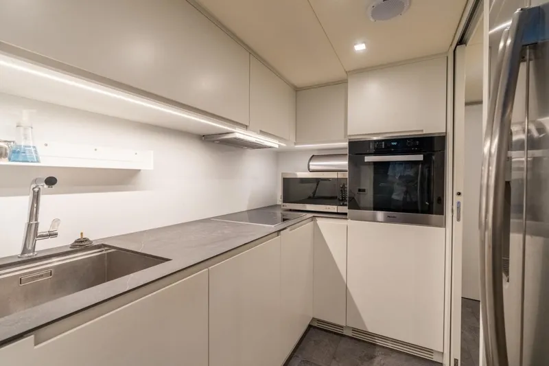 Slide: The Image of Modern kitchen interior in a 2020 Pershing 8X yacht, featuring sleek cabinetry and stainless steel appliances. - 63