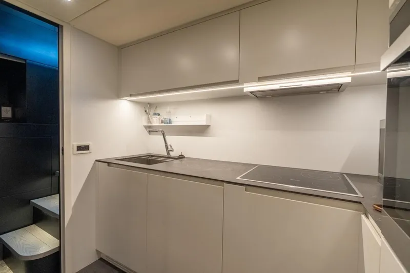Slide: The Image of Modern kitchen interior in a 2020 Pershing 8X yacht, featuring sleek cabinetry and appliances. - 64