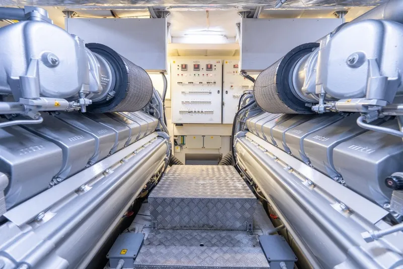 Slide: The Image of Engine room of a 2020 Pershing 8X yacht, featuring advanced machinery and control panels. - 69