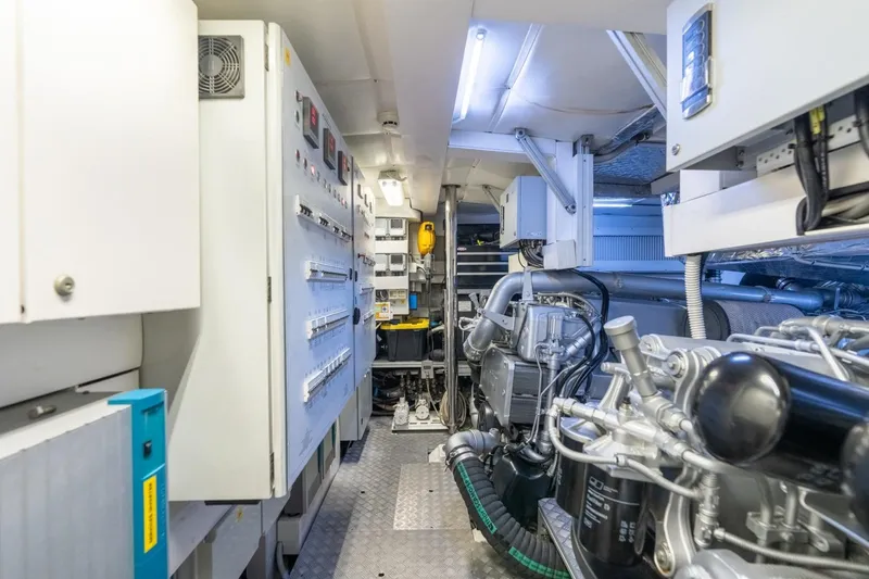 Slide: The Image of Engine room of a 2020 Pershing 8X yacht, showcasing machinery and control panels. - 74