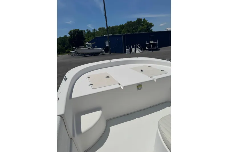 Slide: The Image of 2010 Carolina Skiff 198 DLV boat deck, parked outdoors under clear sky. - 10
