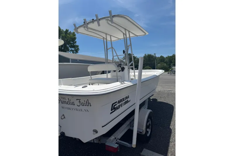 Slide: The Image of 2010 Carolina Skiff 198 DLV boat on trailer under clear blue sky. - 2