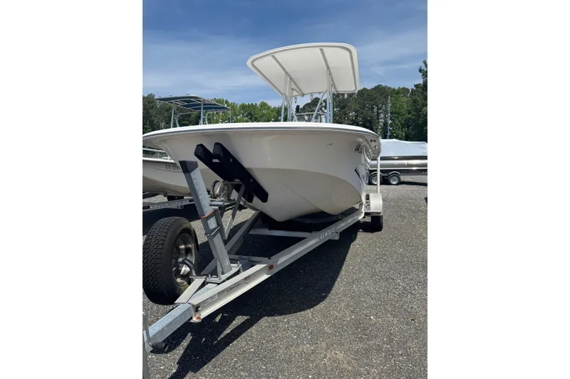Slide: The Image of 2010 Carolina Skiff 198 DLV boat on trailer, parked outdoors under clear sky. - 3
