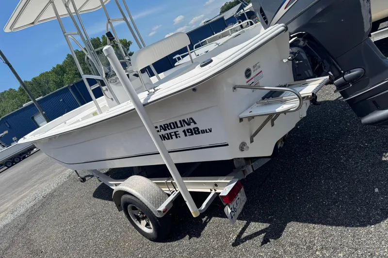 Slide: The Image of 2010 Carolina Skiff 198 DLV boat on trailer, parked outdoors. - 4