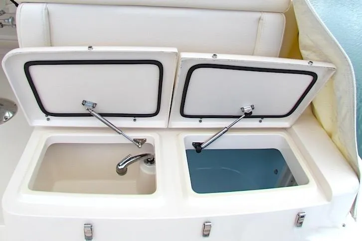 Slide: The Image of 2019 Grady-White Express 370 boat with open storage compartments and faucet. - 12