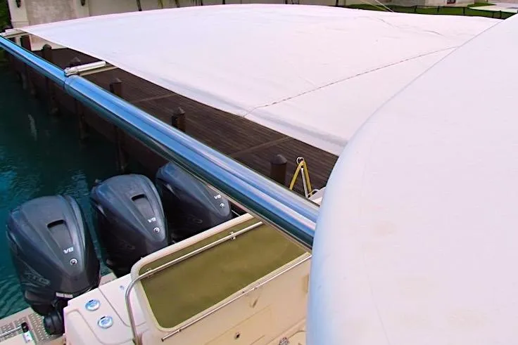 Slide: The Image of 2019 Grady-White Express 370 boat with triple Yamaha outboard engines docked under a canopy. - 17