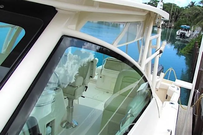 Slide: The Image of 2019 Grady-White Express 370 boat docked by serene waters, showcasing luxurious seating. - 18