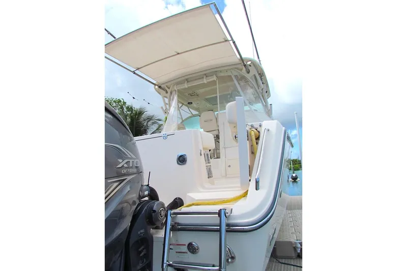 Slide: The Image of 2019 Grady-White Express 370 boat with XTO Offshore engine, docked under a clear sky. - 23