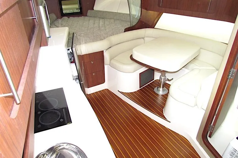 Slide: The Image of 2019 Grady-White Express 370 interior with wood flooring, kitchenette, and cozy seating area. - 26