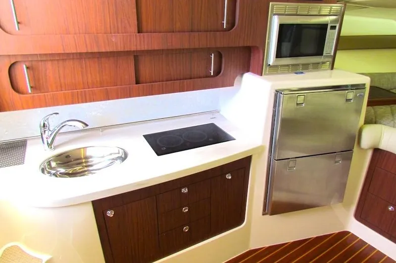 Slide: The Image of 2019 Grady-White Express 370 yacht kitchen with sink, stove, microwave, and fridge. - 27
