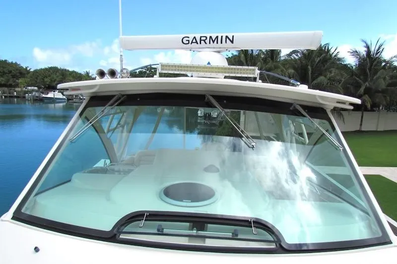 Slide: The Image of 2019 Grady-White Express 370 boat with Garmin radar, docked by a serene waterfront. - 6