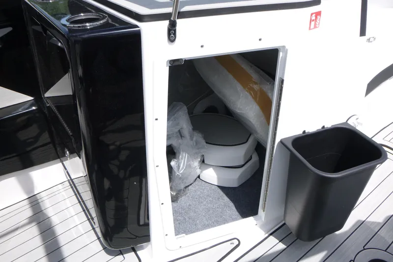 Slide: The Image of Interior storage compartment of 2026 Yamaha Boats 222S, featuring a compact toilet. - 11
