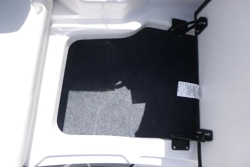 Slide: The Image of Storage compartment of 2026 Yamaha Boats 222S, featuring carpeted interior and hinge details. - 9