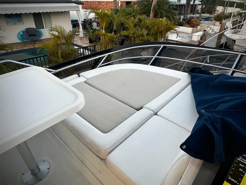 Slide: The Image of 2015 Sea Ray 510 Fly with sun deck and table, surrounded by palm trees. - 18